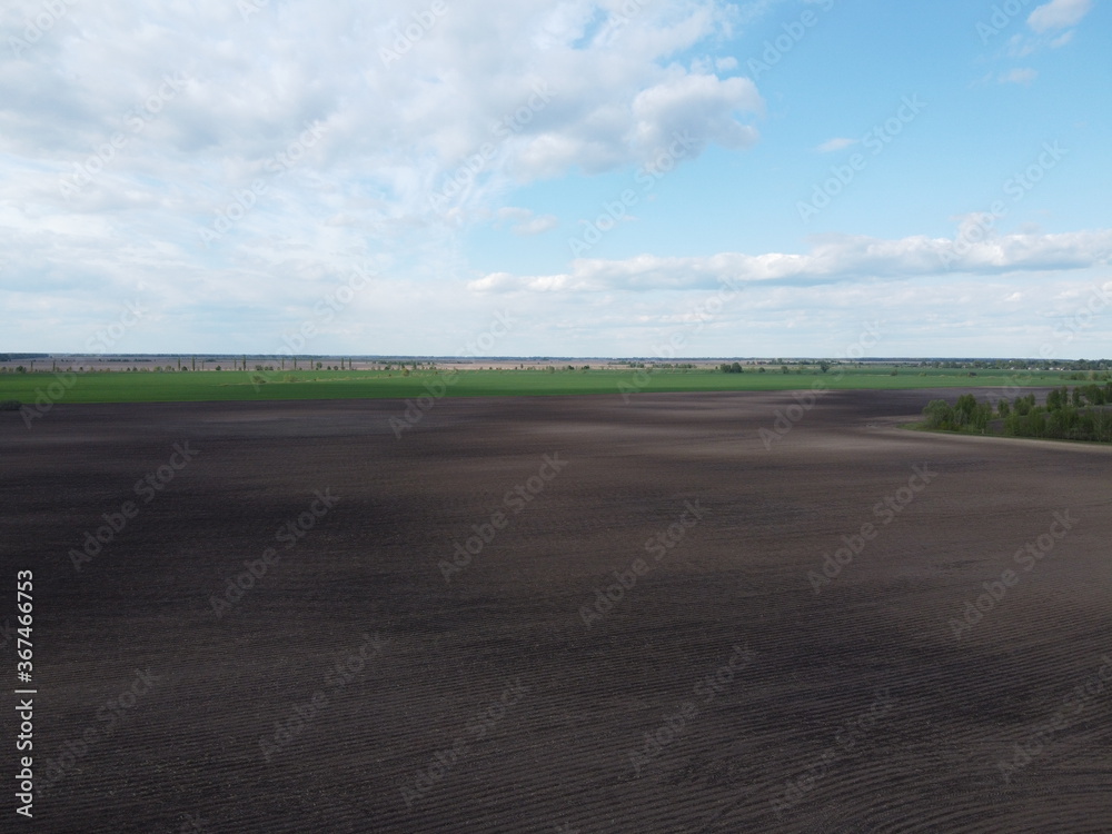 Picturesque farmland, aerial view. Beautiful sky over a plowed field. Picturesque farmland, aerial view. Beautiful sky over a plowed field.