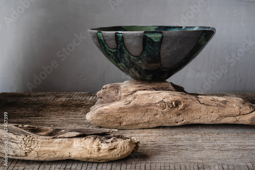 Handmade ceramics in the style of wabi sabi. Grey clay bowl with an abstract green pattern. photo