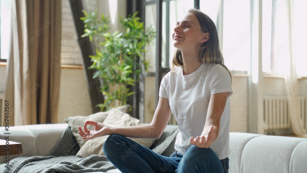 Attractive young woman exercising and sitting in yoga lotus position Attractive young woman exercising and sitting in yoga lotus position