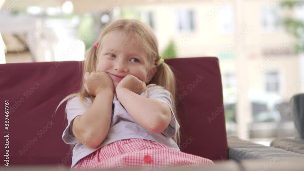 A cute little girl having fun at a table in a cafe. A cute little girl having fun at a table in a cafe.