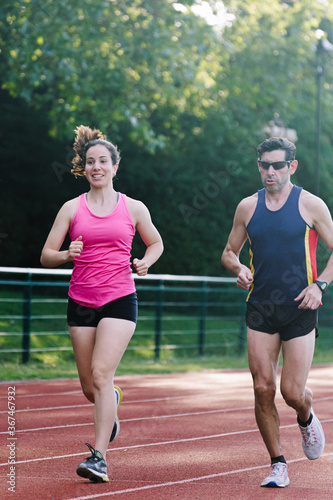 Active sporty woman and man in sportswear running. Selective focus on the them and defocused background.