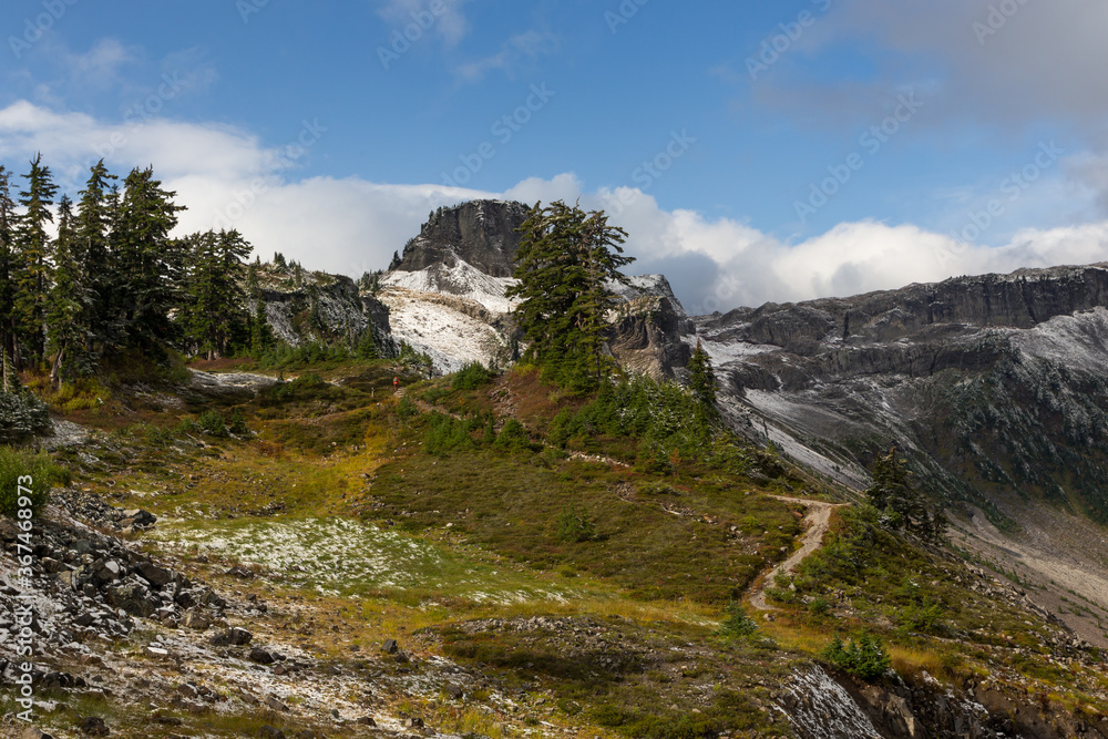 Hiking trail in mountains area. North Cascades National park, Washington, USA. Fresh snow clouded nearby hills
