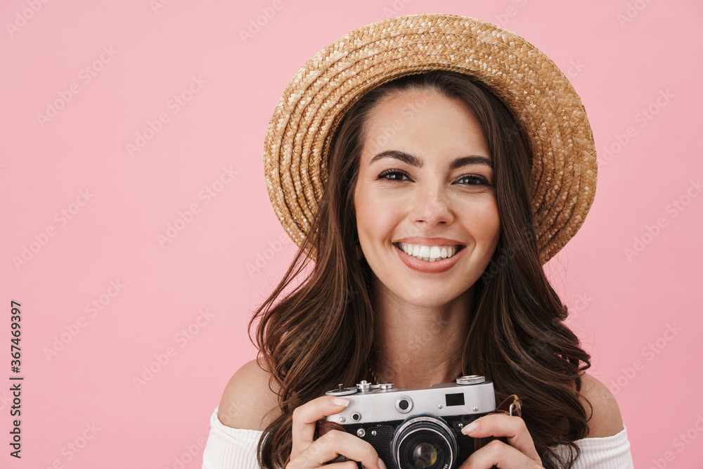 Image of joyful brunette woman taking photo on retro camera