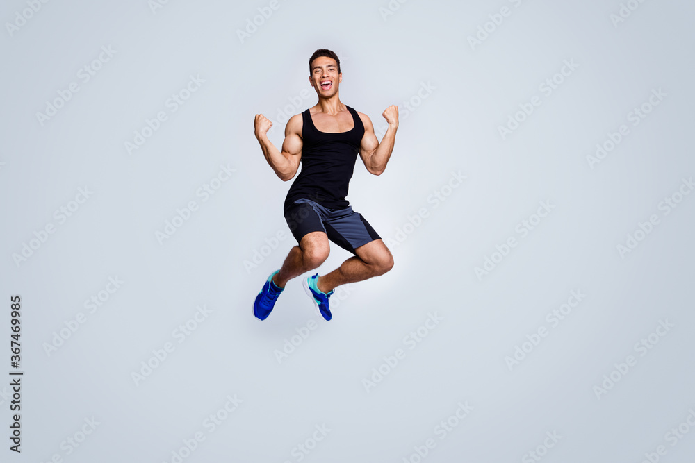 Full length body size view of his he nice attractive sportive muscular cheerful glad guy jumping celebrating great accomplishment rejoicing isolated over light gray pastel color background