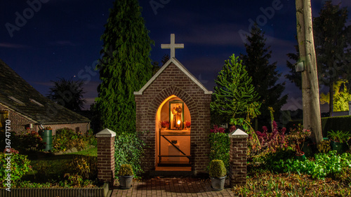 Fotografia Little chapel  with Antonius of Padua with burning candles during a starry sky