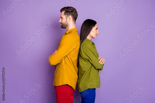 Profile photo cool lady handsome guy standing back-to-back arms crossed confident partners team look empty space wear casual bright shirts outfit isolated purple color background © deagreez