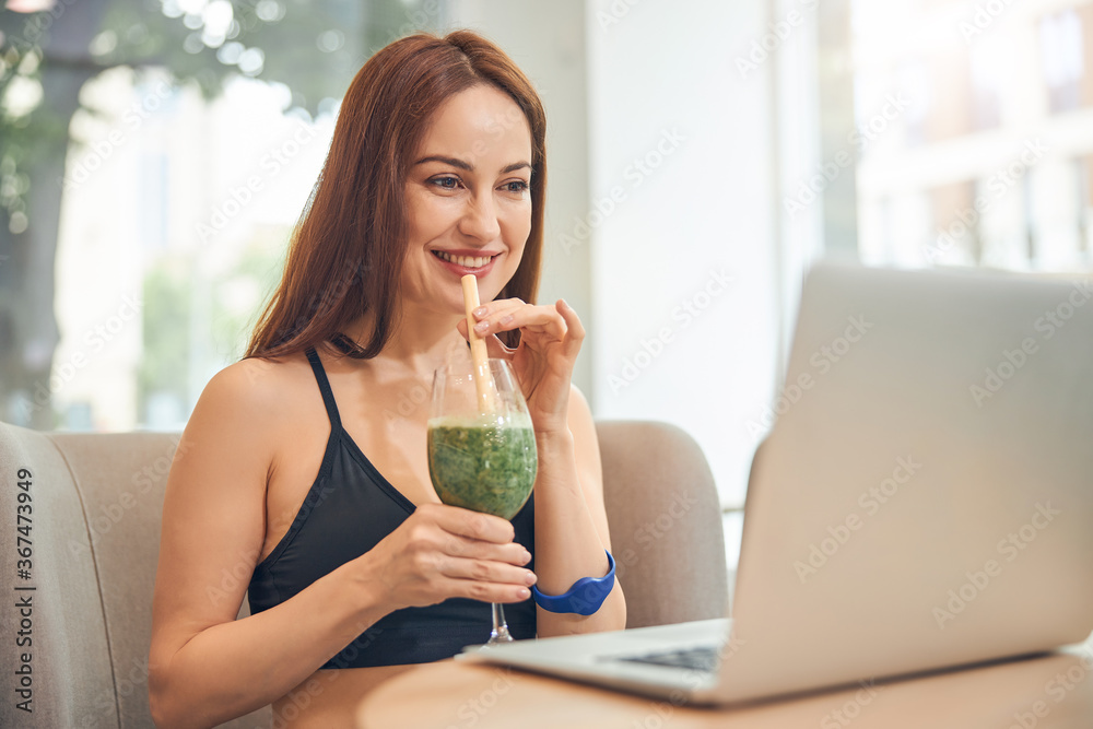 Smiling woman gazing at the laptop screen Smiling woman gazing at the laptop screen