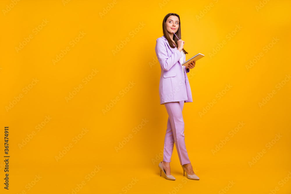Full length photo of pretty business lady hold diary write notes for boss corporate conference have creative idea pencil on chin wear purple office suit isolated yellow color background Full length photo of pretty business lady hold diary write notes for boss corporate conference have creative idea pencil on chin wear purple office suit isolated yellow color background