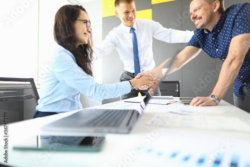 Valokuva Businessmen and businesswoman in their office smiling and shaking hands