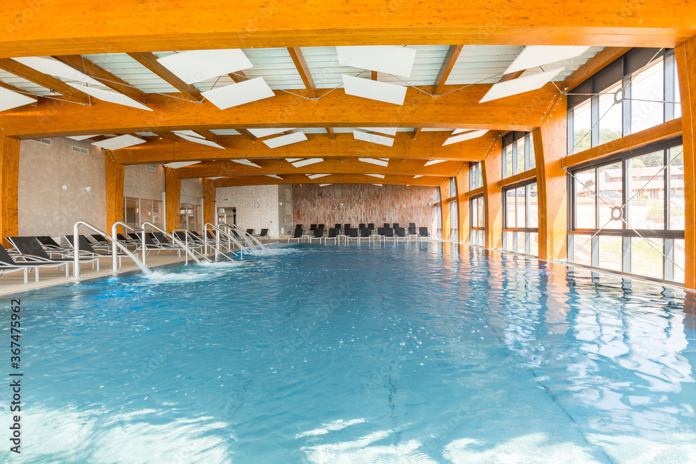 Obraz premium Stainless steel pool massage spa shower water curtain, indoor mini waterfall in indoor swimming pool in hotel spa and wellness center