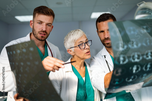 Doctors discussing patient's diagnosis looking at x-rays in a hospital