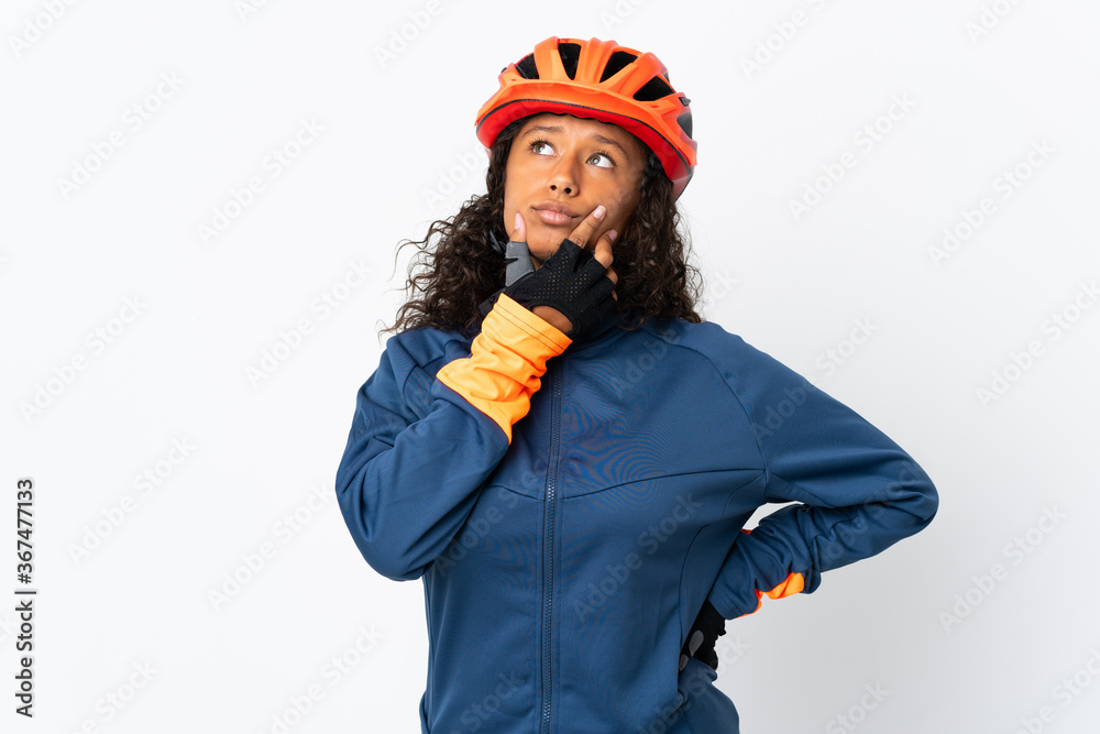 Teenager cyclist woman isolated on white background having doubts Teenager cyclist woman isolated on white background having doubts