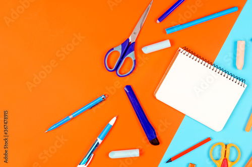 School supplies on blue and orange background. Education concept. photo