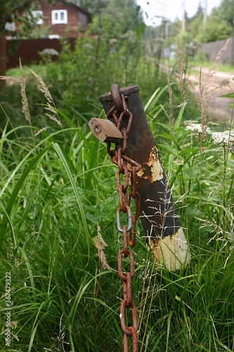 a metal column with a rusty chain and a padlock