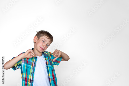 Portrait of a disgruntled boy making thumbs down hand gesture. The boy does not want to study. Learning concept