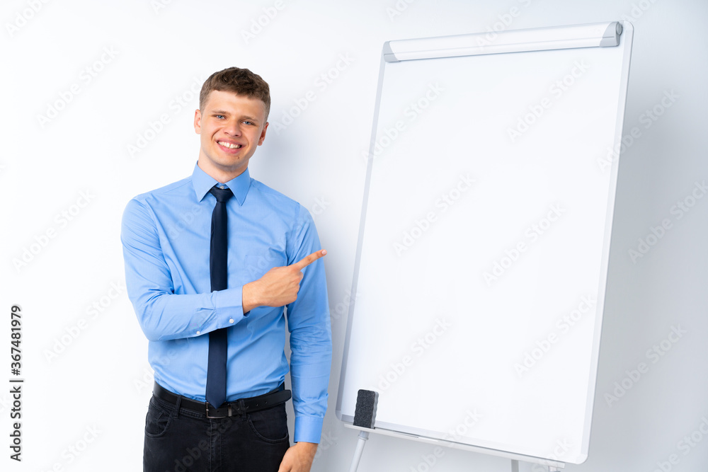 Young businessman giving a presentation on white board pointing to the side to present a product Young businessman giving a presentation on white board pointing to the side to present a product