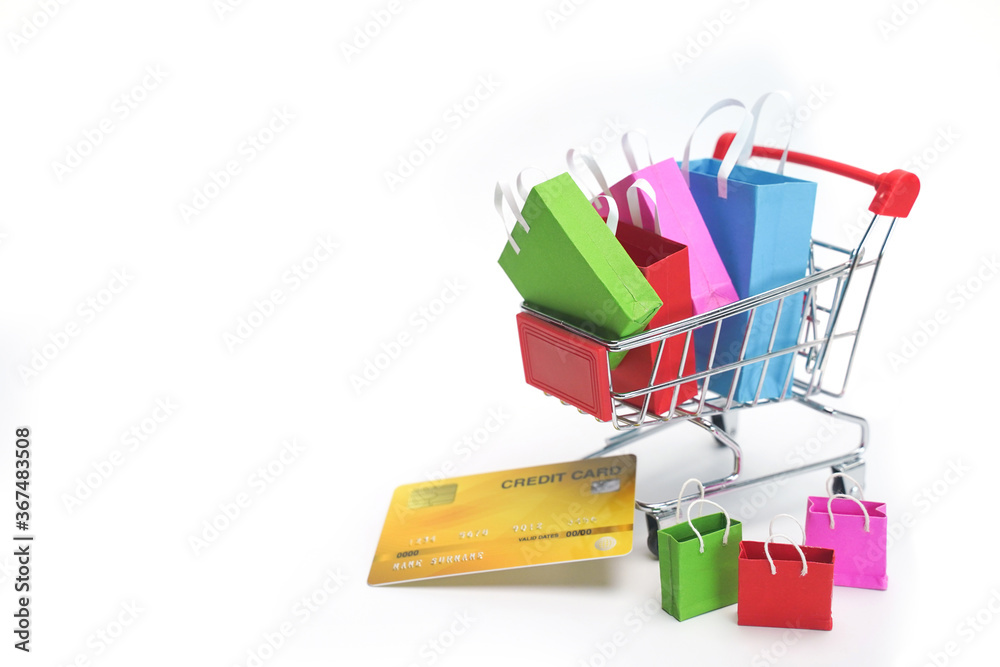 Colorful shopping bags in the cart with credit card on white background. Shopping service on online web and offers home delivery.  online shopping concept.