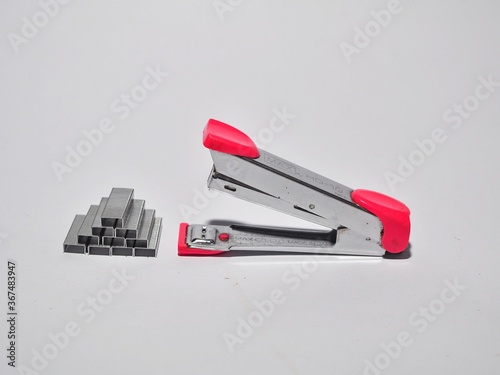 Pink stapler and staples isolated on white background. Office work equipment concept