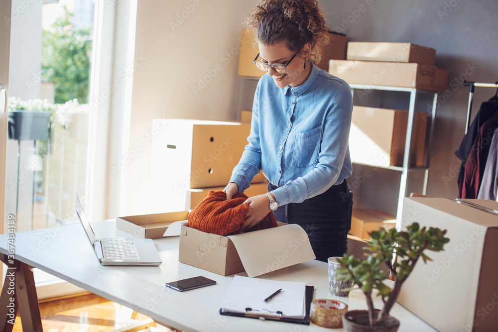 Small business owner. Women, owner of small business packing product in boxes preparing it for delivery. Small business owner. Women, owner of small business packing product in boxes preparing it for delivery.