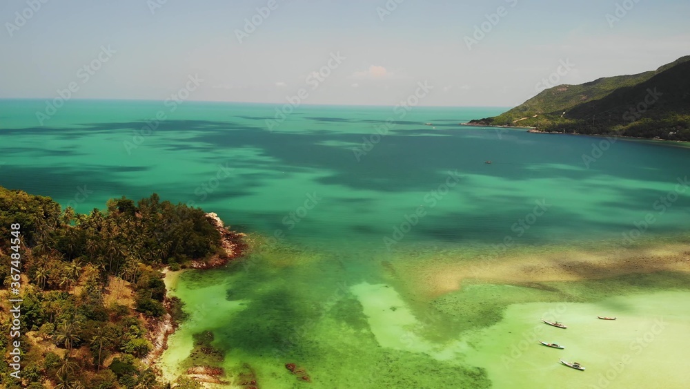Fototapeta premium Aerial drone view island Koh Phangan Thailand. Exotic coast panoramic landscape, Chaloklum Malibu fisherman beach, summer day. Sandy path, corals. Vivid seascape, mountain coconut palms from above.