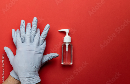 Protection covid. Medical antibacterial sanitizer gel, lab gloves - Virus protection equipment on red background. Dangerous Novel virus COVID-19, pandemic risk alert photo