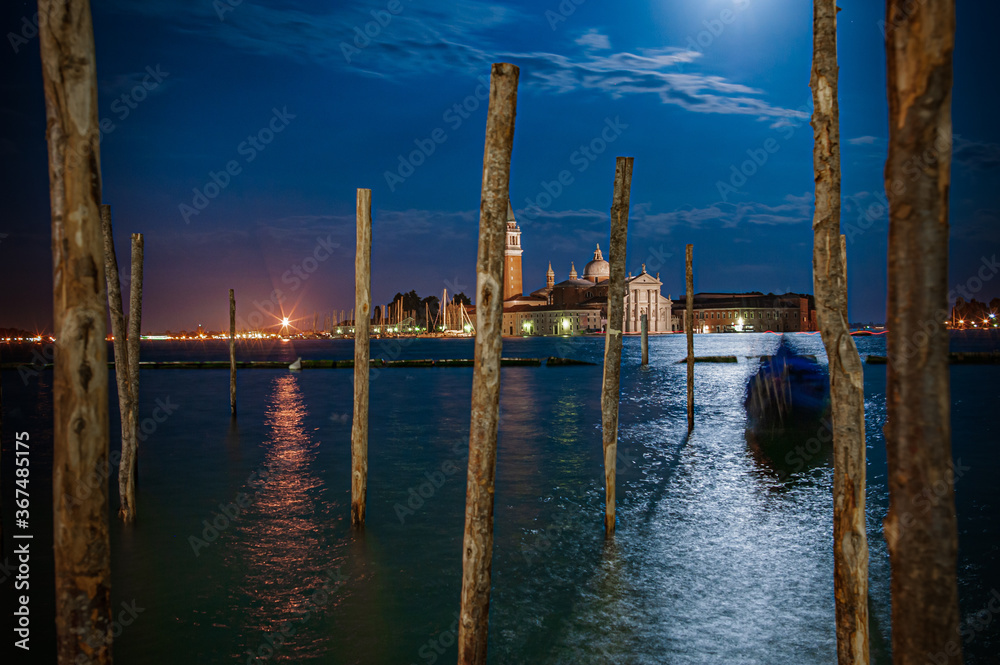 View of gondolier posts in Venice moonlit harbour
