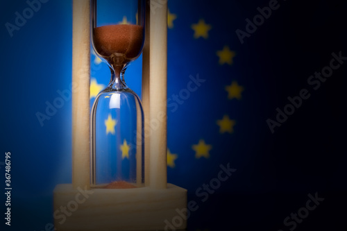 Hourglass and European Union flag, soft focus, copy space