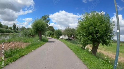 POV driving over dike at the river Amstel in Holland with Dutch houses photo