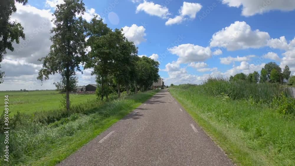 POV driving over dike at the river Amstel in Holland with Dutch houses POV driving over dike at the river Amstel in Holland with Dutch houses