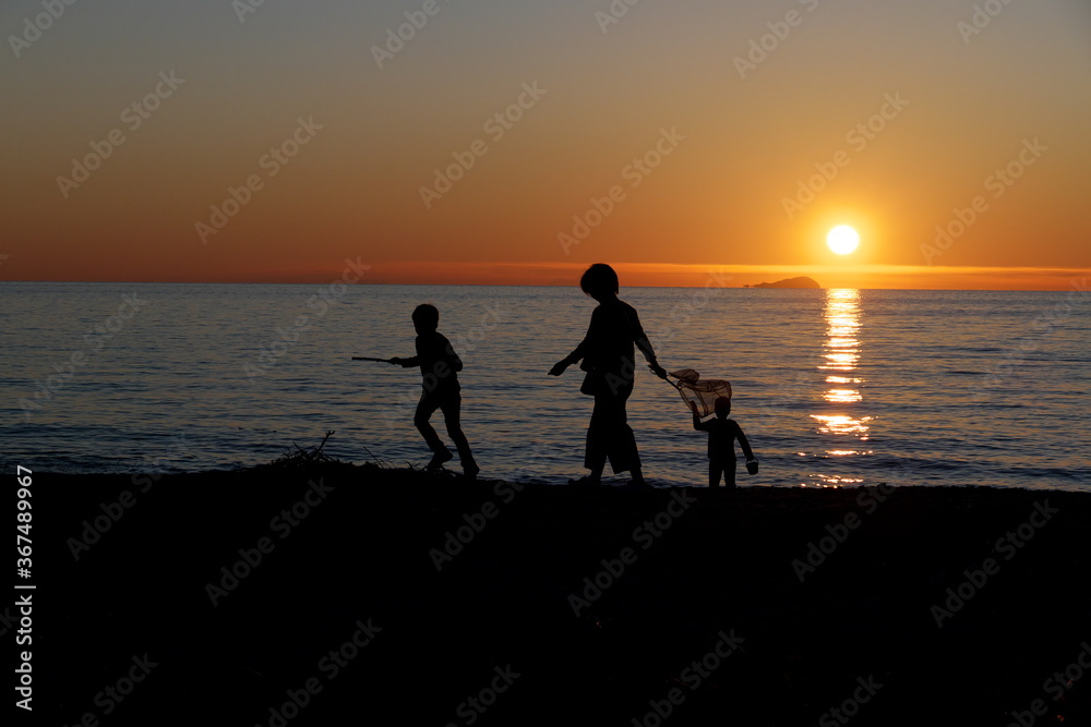 日没前の浜辺の親子連れ
