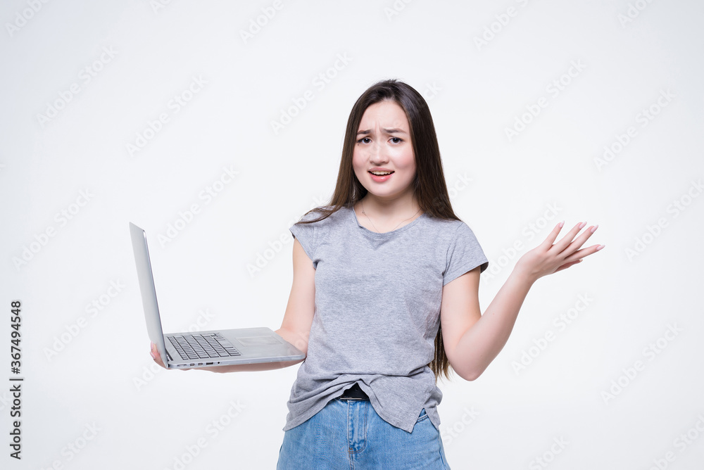 Naklejka premium Beautiful portrait young asian business woman holding laptop isolated on white background. Businesswoman looking notebook with surprise and amazing, asia freelance girl work job and wonderful