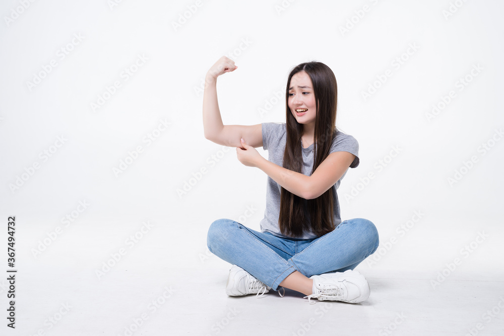 Young asian girl sitting on the floor feeling happy, satisfied and powerful, flexing fit and muscular biceps isolated on white background Young asian girl sitting on the floor feeling happy, satisfied and powerful, flexing fit and muscular biceps isolated on white background