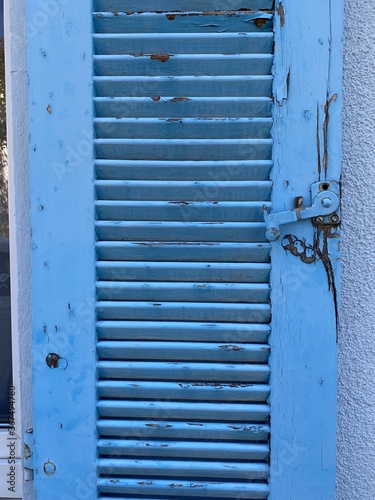 Hellblauer Fensterladen aus Holz mit Lammelen retro