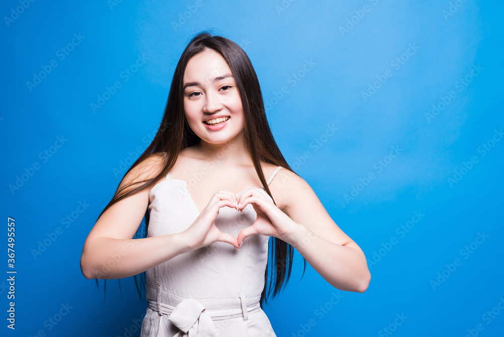 Asian pretty woman make heart shape hands love sign concept, healthy skin , isolated portrait blue color background Asian pretty woman make heart shape hands love sign concept, healthy skin , isolated portrait blue color background