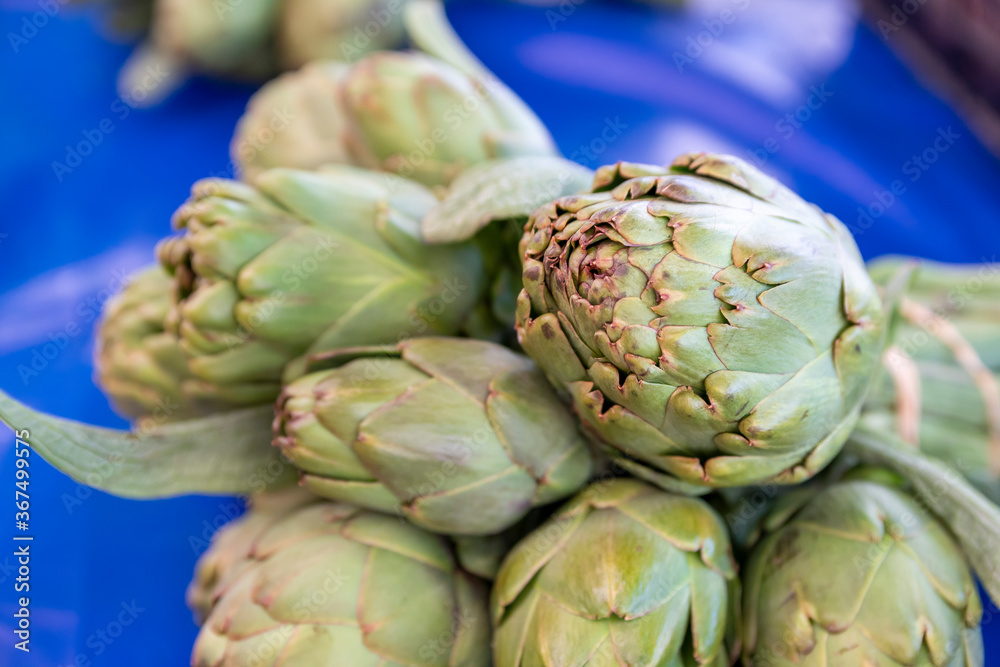 Obraz premium Fresh and organic artichokes on market stall.