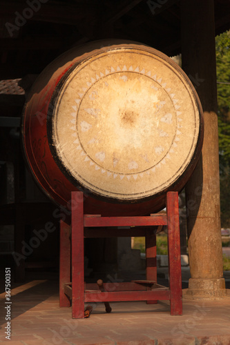 Red wooden drum on frame at entrance to Buddhist temple in Vietnam