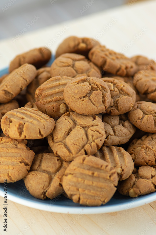 Very tasty peanut butter biscuits on bamboo light brown wooden board, golden baked healthy Very tasty peanut butter biscuits on bamboo light brown wooden board, golden baked healthy
