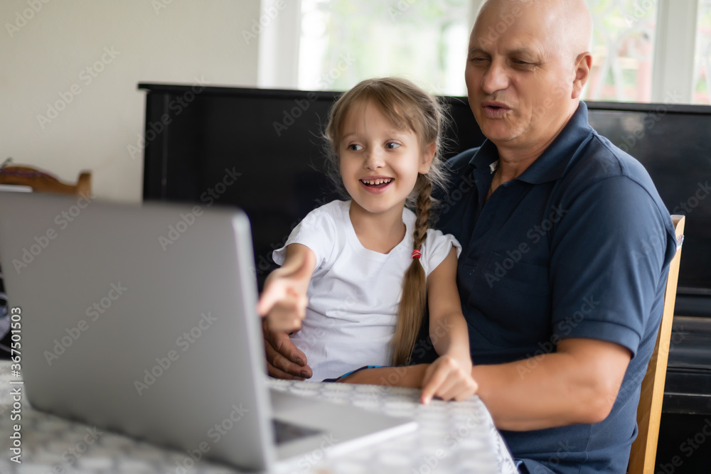 Grandfather and his granddaughter using a laptop together. Grandfather and his granddaughter using a laptop together.