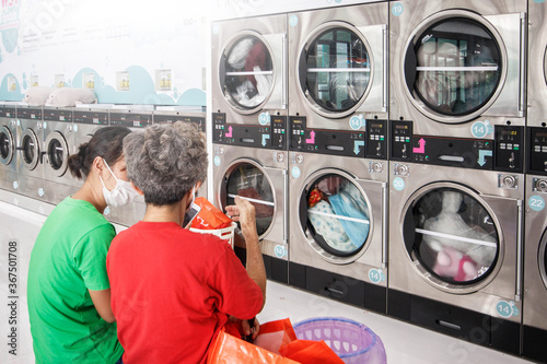 Asia old people washing clothes at the laundry shop. photo