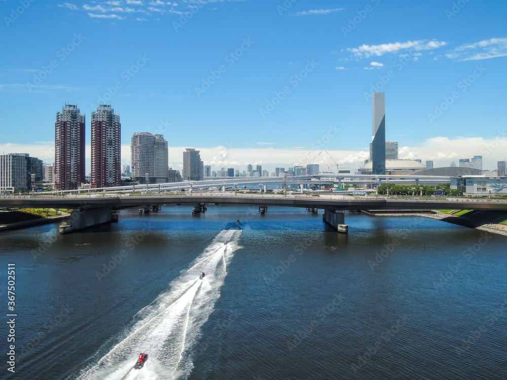 Naklejka premium お台場の運河を走り抜けるジェットスキー 新交通ゆりかもめ線からの車窓風景