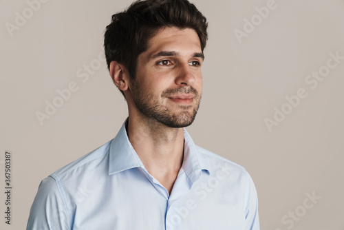 Image of pleased businesslike brunette man looking aside