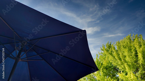 Fotografie Sombrilla en una terraza arbolada