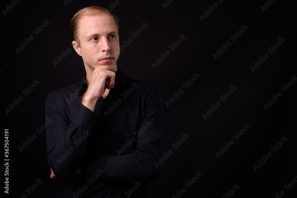 Businessman with blond hair against black background Businessman with blond hair against black background
