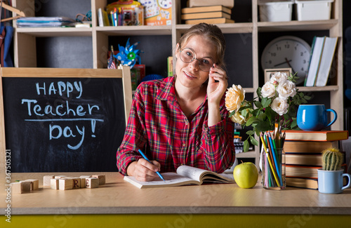 Formal education. Teacher pretty woman enjoy educational process in classroom. Teachers day.  (Soft focus on girl)Young teacher in glasses over green chalkboard background. Beautiful teacher in classr photo