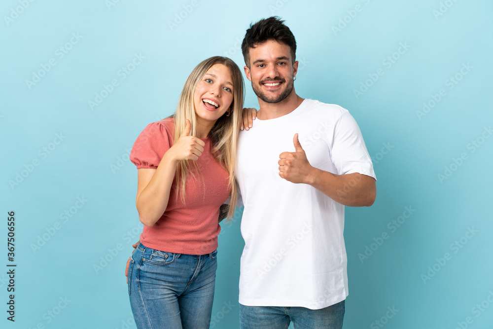 Young caucasian couple isolated on blue background giving thumbs up gesture Young caucasian couple isolated on blue background giving thumbs up gesture