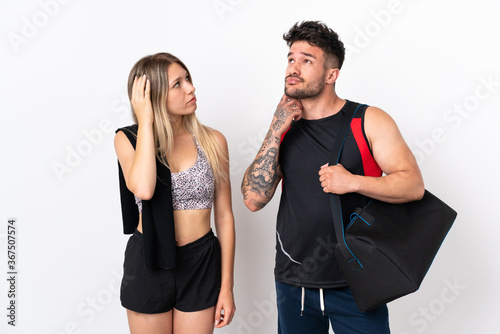 Young sport couple isolated on white background thinking an idea while scratching head