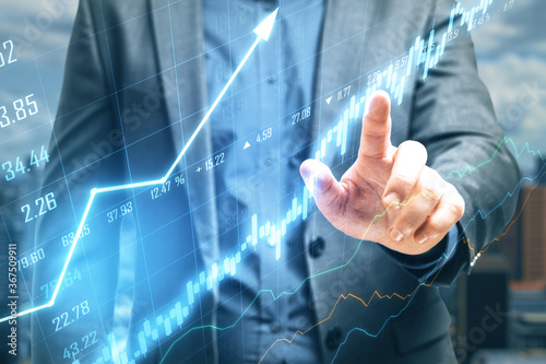 Businessman hand pointing at stock chart screen interface with data.