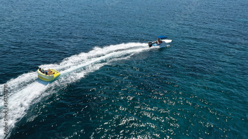 Aerial drone tracking photo of extreme power boat donut water-sports cruising in high speed in open ocean deep blue bay