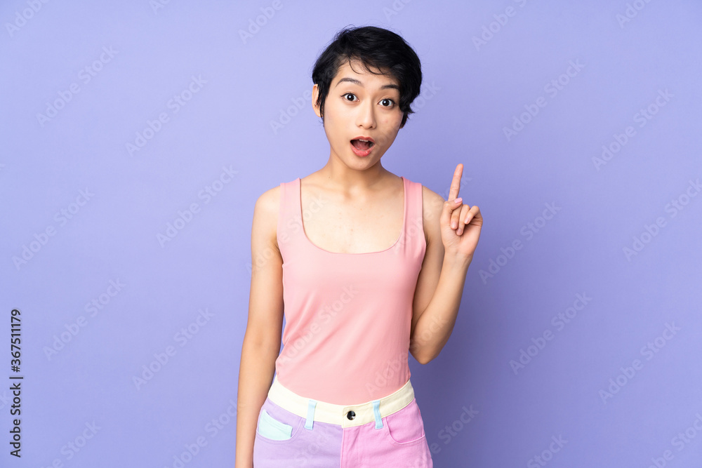 Young Vietnamese woman with short hair over isolated purple background thinking an idea pointing the finger up Young Vietnamese woman with short hair over isolated purple background thinking an idea pointing the finger up