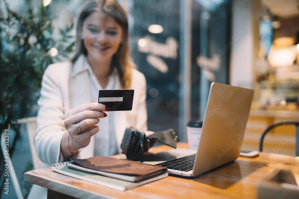 Blurred female checking cvv code on plastic debit card enjoying leisure shopping during Cyber Monday, skilled woman using security verification for transfer transaction looking for safety web order